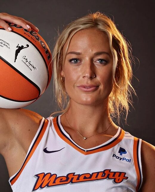 Sophie Cunningham, jogadora da WNBA, posando com uma bola de basquete no ombro, vestindo o uniforme do Indiana Fever