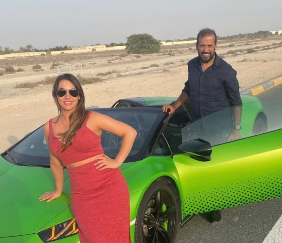 Casal ao lado de uma Lamborghini verde na estrada do deserto entre Dubai e Abu Dhabi